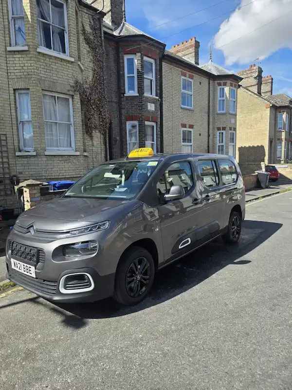 Back view of WAV taxi with accessibility ramp down for Newmarket travel.